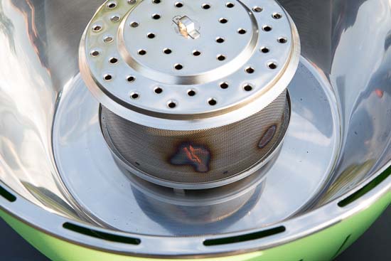 Beholderen til kullene sidder midt i grillen
