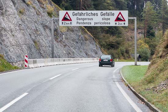 Skiltet henover vejen siger det ret tydeligt. En lang og farlig nedkørsel begynder her, så det var bare om at få gearet ned og komme ned i fart