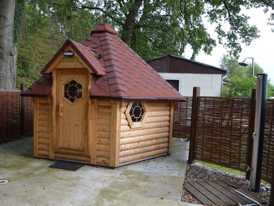 Sauna med udendørs bruser og stole til afslapning, ligger centralt i naturistafsnittet.