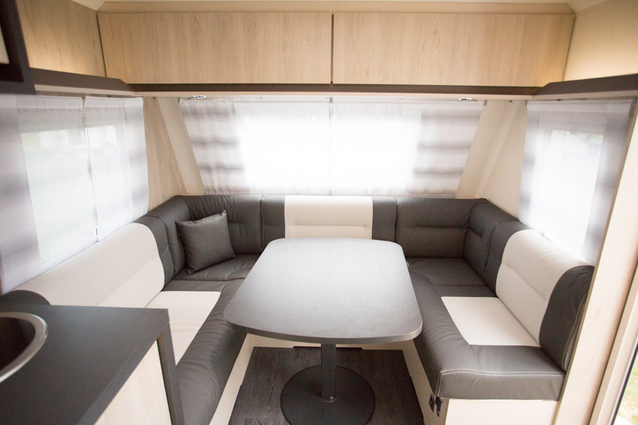 Siddegruppen i Artica 455 er holdt i lyse farver, og der to dybe overskabe og hylder over siddegruppen