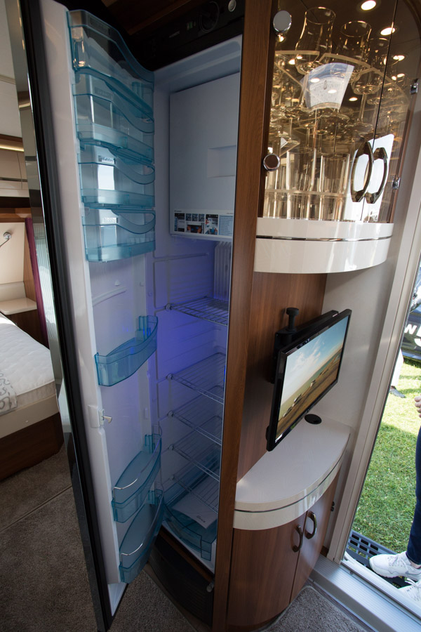 Køleskabet er placeret midt i vognen. Her er også vitrineskab på den ene side og garderobeskab på den anden